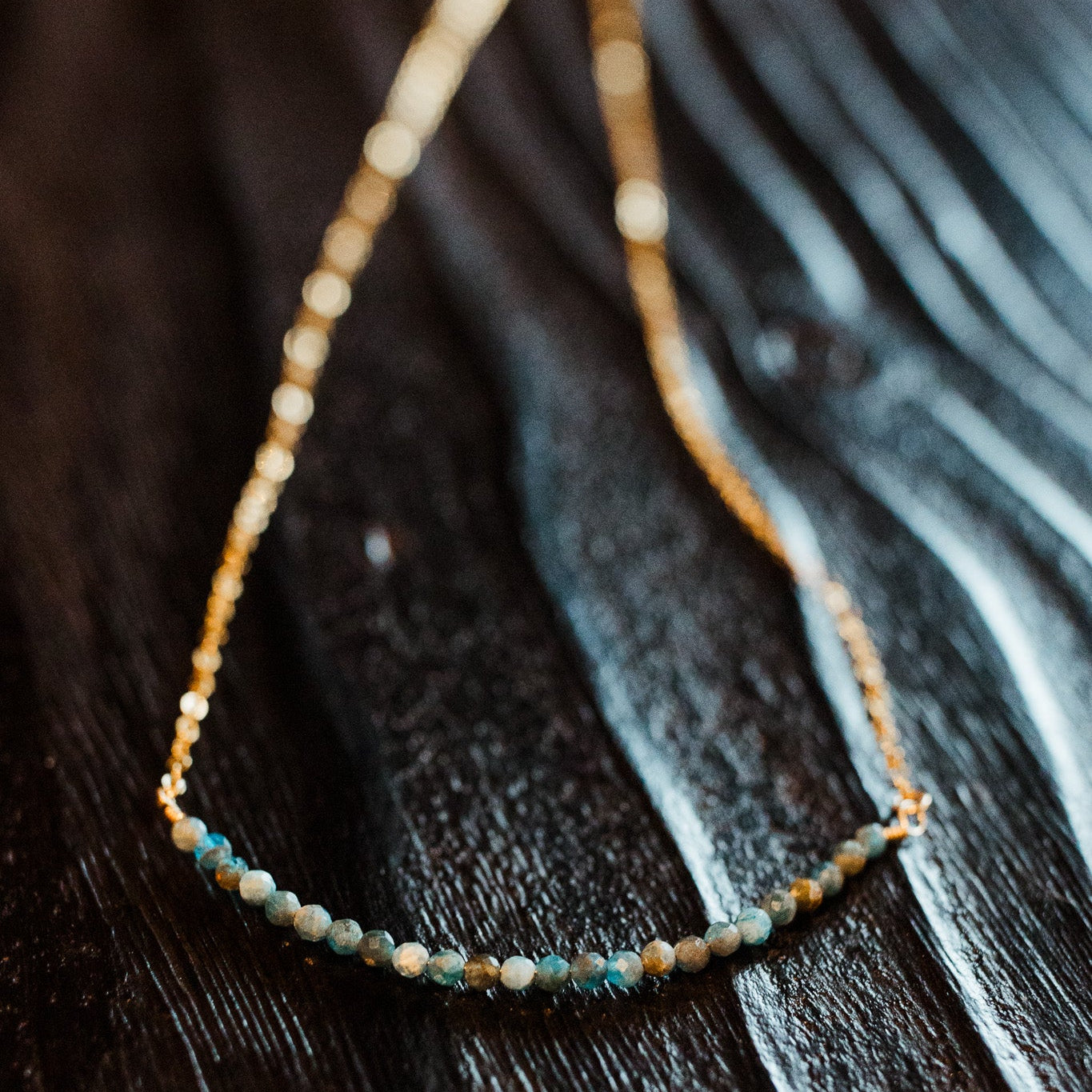 Apatite rondelle bar necklace with 16-inch gold-filled chain featuring 24-26 blue apatite beads on a 3-inch curved wire