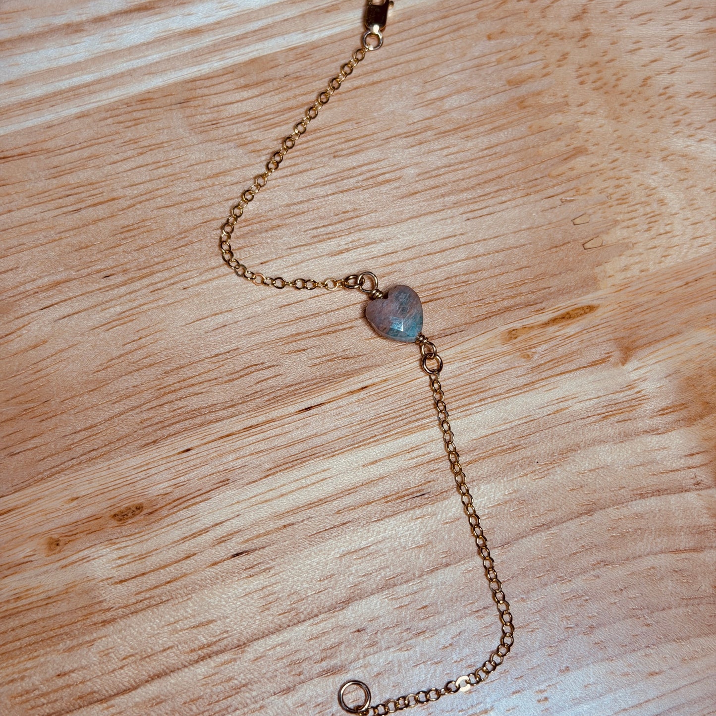 Gold filled chain with amazonite heart bead on a wooden surface