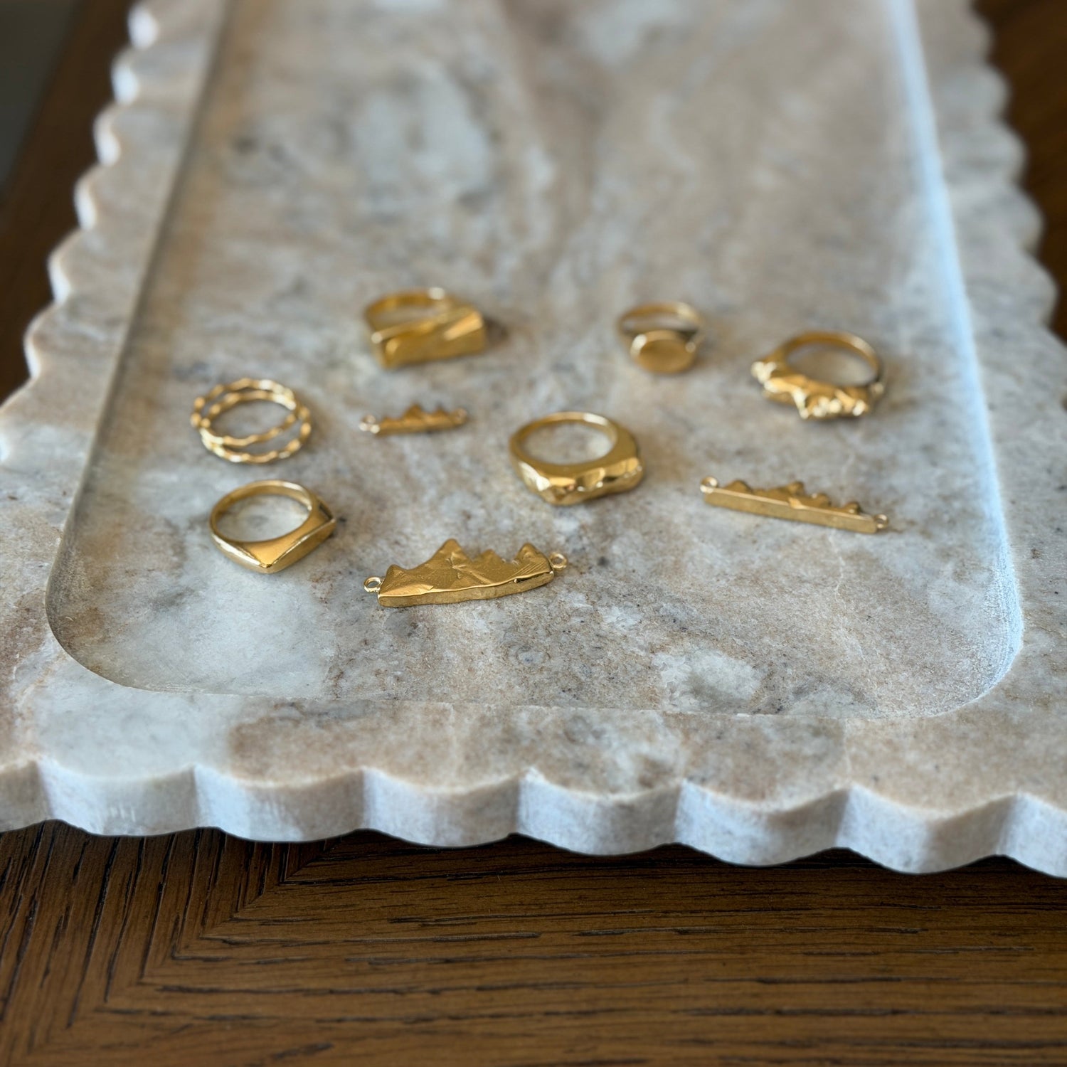 Gold vermeil rings and pendants on a marble tray