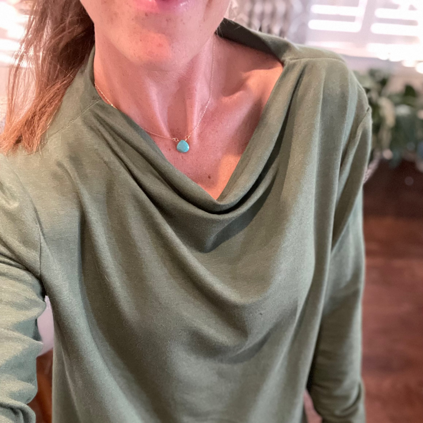 Woman wearing a delicate turquoise briolette necklace on a 15-inch gold-filled chain, sitting at collarbone length, perfect for everyday layering and minimalist style.